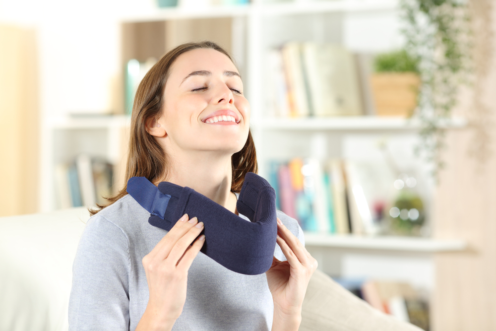 A woman uses a neck brace after an auto accident, representing whiplash recovery and the importance of professional chiropractic care - Boynton Beach Car Accident Whiplash