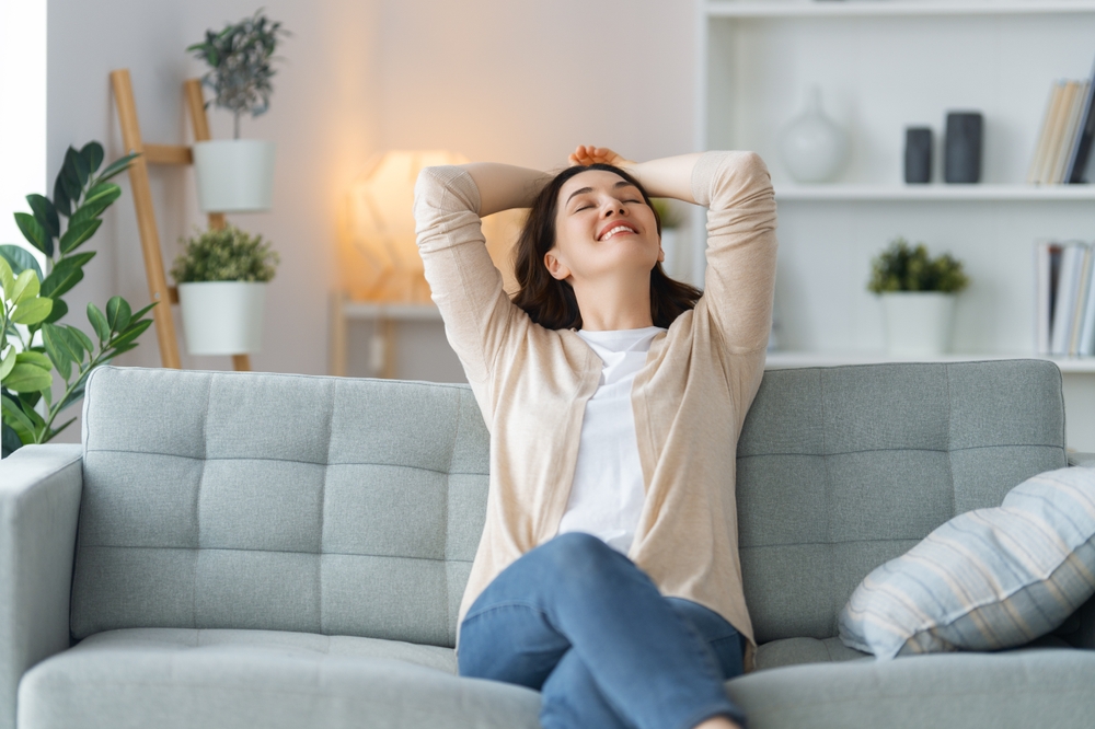 A woman relaxes at home after successful recovery from whiplash pain, showing the benefits of chiropractic care and injury rehabilitation